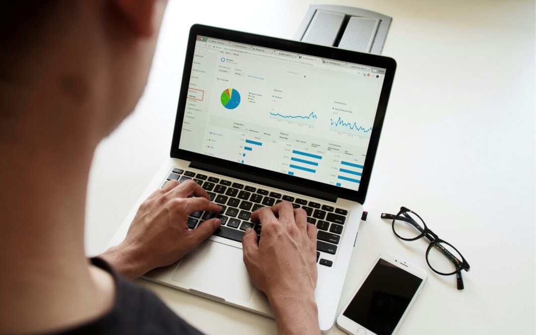 Bidikan di atas bahu seseorang yang melihat dasbor real-time di laptop mereka untuk membuat keputusan berdasarkan data