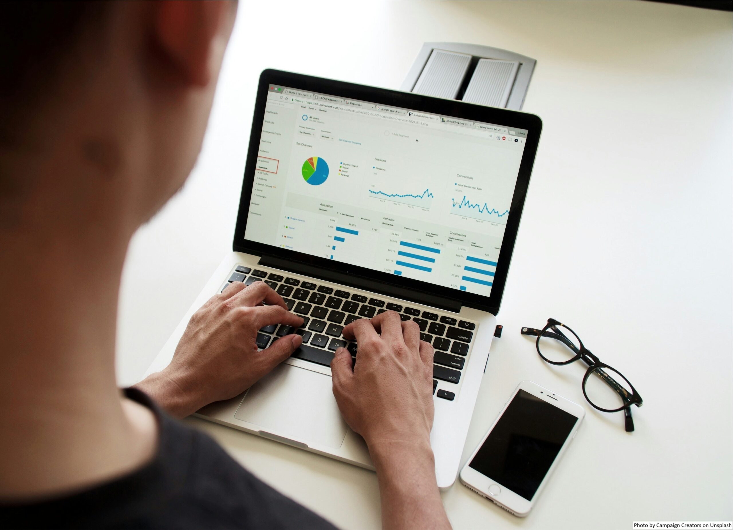 Bidikan di atas bahu seseorang yang melihat dasbor real-time di laptop mereka untuk membuat keputusan berdasarkan data