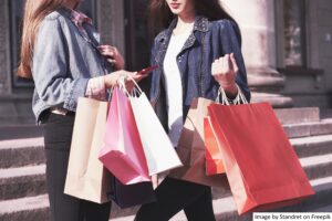 Woman holding shopping bags after shopping at a retailer using a unified commerce platform