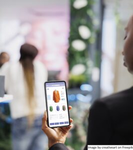 A woman using a mobile app of the retail store that she is in, improving the retail store’s customer loyalty by providing an omnichannel experience.
