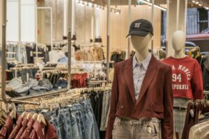 Interior of a large fashion retail store with clothing displays and mannequins across an open shop floor